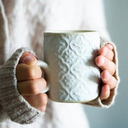 Coffee beans pouring from a burlap sack onto a rustic wooden surface